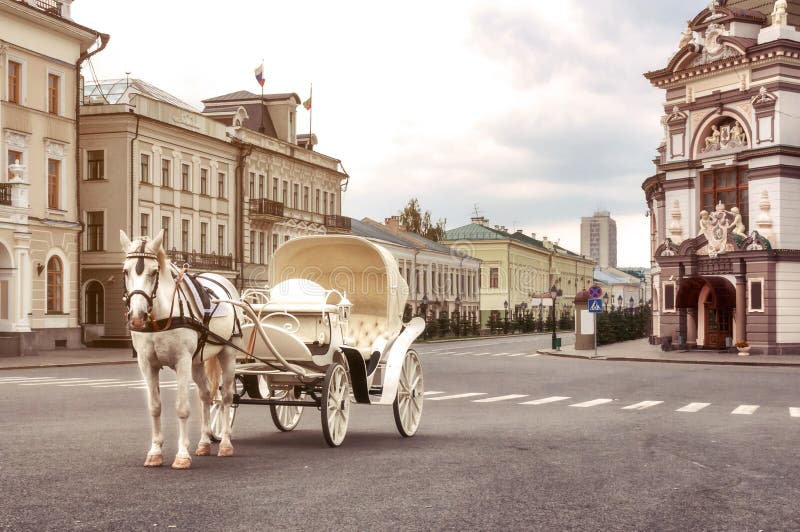 Emoty white carriage with white horse waits for tourists in central square, Kazan, Russia. Emoty white carriage with white horse waits for tourists in central square, Kazan, Russia