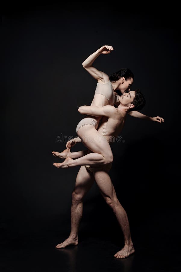 Charismatic young performers dancing in the black colored studio royalty free stock photography