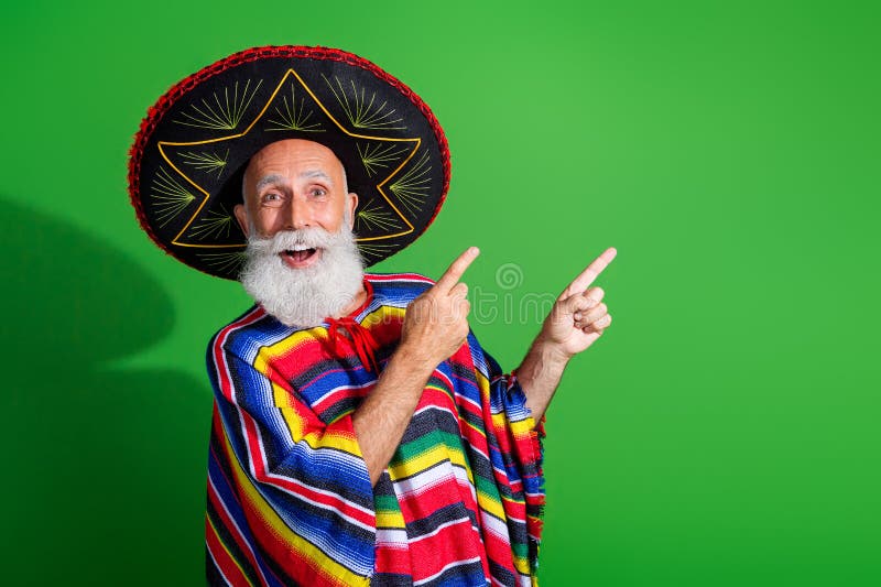 Charismatique homme âgé dans une tenue mexicaine colorée arborant fièrement l'énergie festive sur un fond vert vibrant photos stock