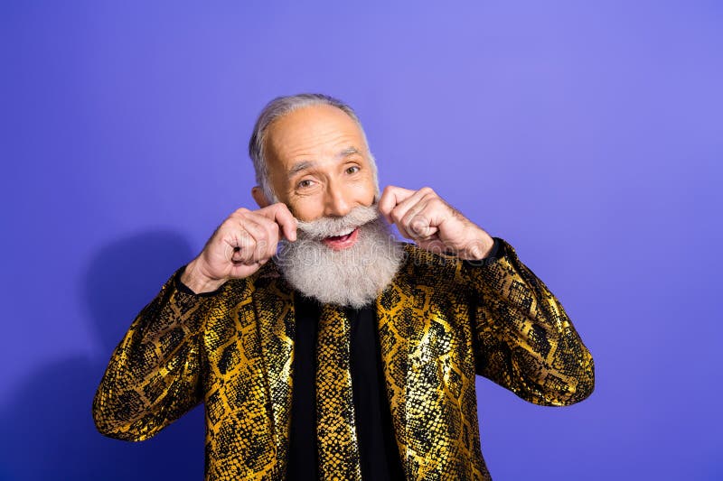 Charismatique homme âgé posant dans une veste d'or excentrique sur fond violet images libres de droits