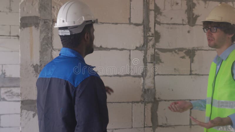 Charlas de arquitectos y constructores y construcción de inspectores en el contratista de la construcción y discusión de trabajado