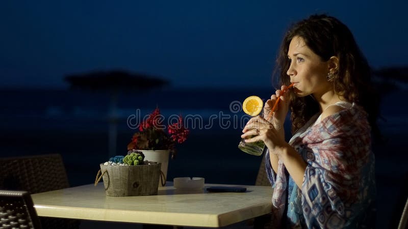 Charmante jonge dame het drinken cocktail bij kustrestaurant dichtbij haar hotel royalty-vrije stock fotografie Charmante jonge dame het drinken cocktail bij kustrestaurant dichtbij haar hotel royalty-vrije stock fotografie