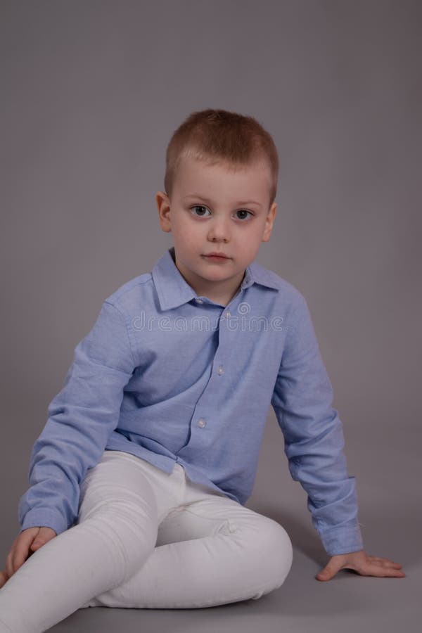 Charmante Kleine Voorschooljongen in Witte Broek En Blauw Shirt Op Grijze Achtergrond. Stock Foto Image blond: 223820486