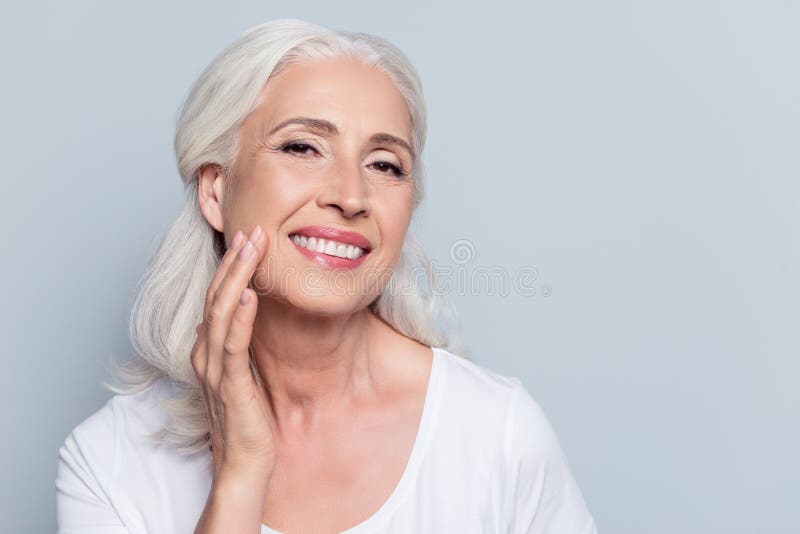 Charme, joli, dame âgée touchant sa peau molle parfaite de visage images libres de droits