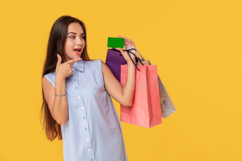 Charmerend vrij aantrekkelijk sexy meisje die creditcard tonen en vele kleurrijke pakketten in hand houden, is het comfortabel stock afbeelding Charmerend vrij aantrekkelijk sexy meisje die creditcard tonen en vele kleurrijke pakketten in hand houden, is het comfortabel stock afbeelding