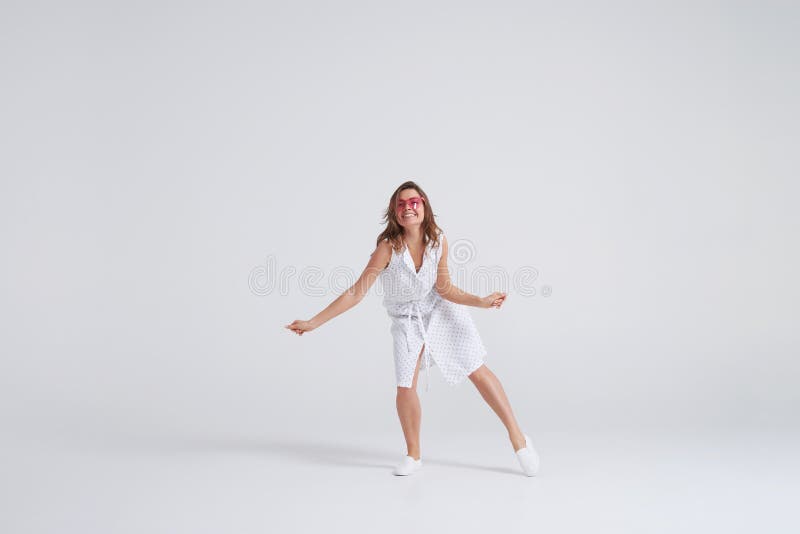 Charmig ung kvinna i klänningen som har gyckel på studion royaltyfri fotografi Charmig ung kvinna i klänningen som har gyckel på studion royaltyfri fotografi