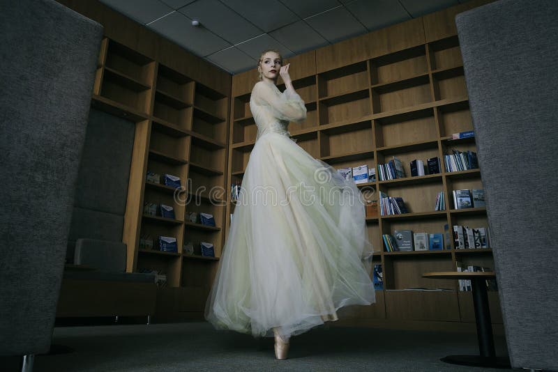 charming ballerina went to the library to choose a new book during a break showing your stretching and flexibility