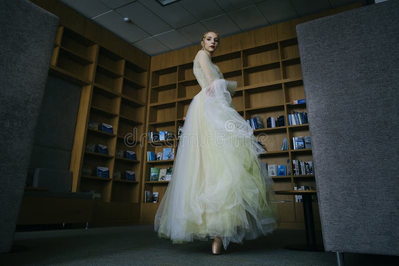 charming ballerina went to the library to choose a new book during a break showing your stretching and flexibility