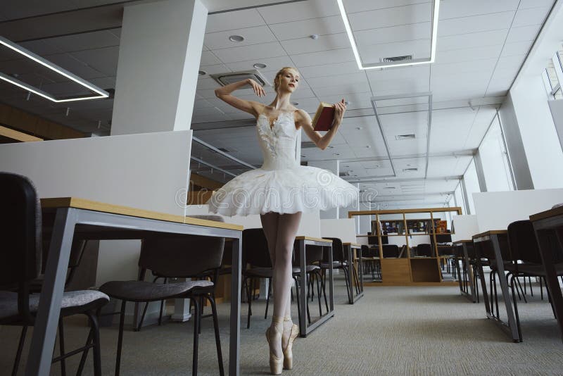 charming ballerina went to the library to choose a new book during a break showing your stretching and flexibility