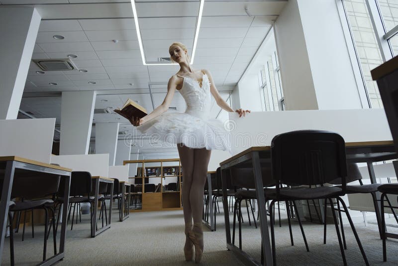 charming ballerina went to the library to choose a new book during a break showing your stretching and flexibility