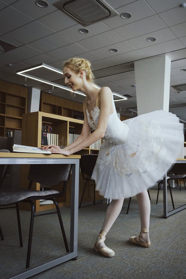 charming ballerina went to the library to choose a new book during a break showing your stretching and flexibility