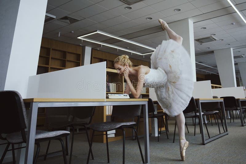 charming ballerina went to the library to choose a new book during a break showing your stretching and flexibility