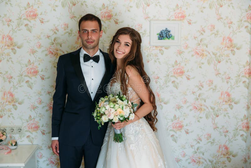 Charming couple wedding couple on wedding day smiling. Happy family, groom in a black suit, businessman and bride with a stock photo Charming couple wedding couple on wedding day smiling. Happy family, groom in a black suit, businessman and bride with a stock photo