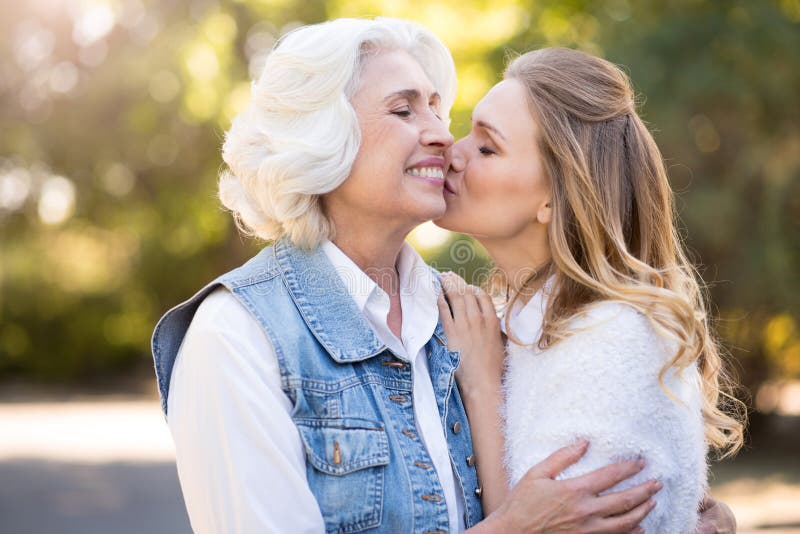 Charming cute girl kissing her mother in the cheek . stock image.