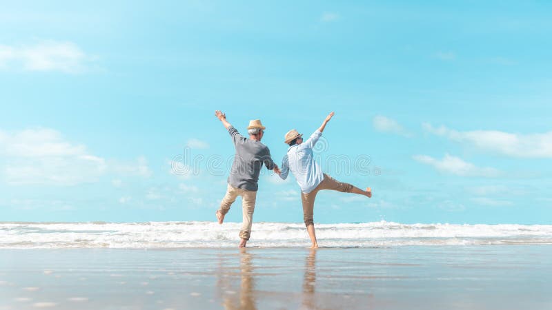 Charming elderly couple went to the beach to enjoy the sea breeze