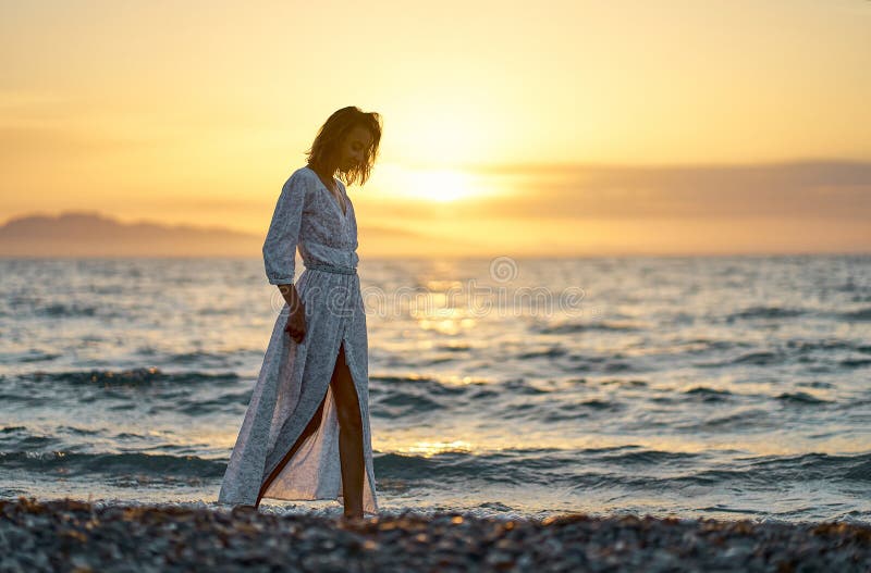 Charming Elegant Tourist Woman Strolling Near Seashore On Beach During