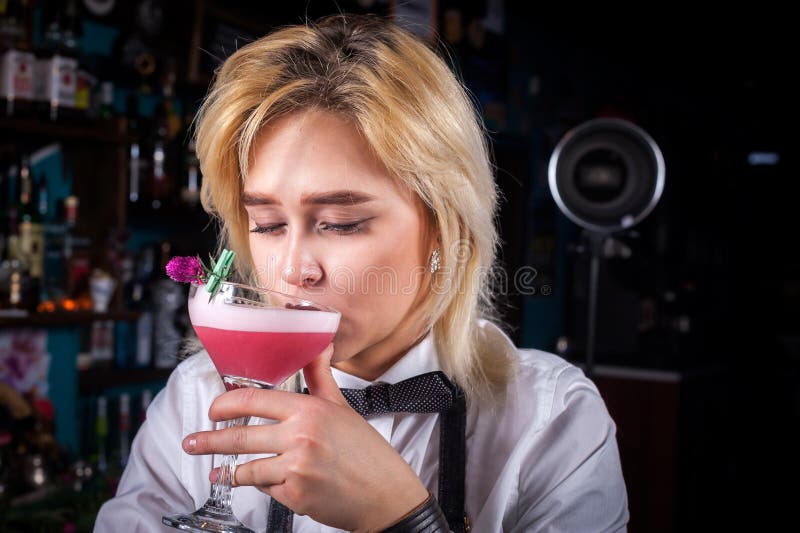 Young Woman Bartending Creates a Cocktail while Standing Near the Bar ...
