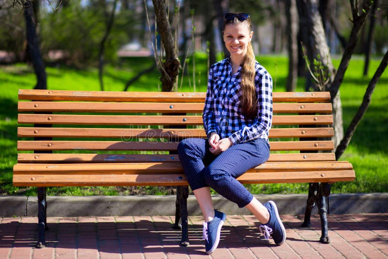 Charming girl walking in park and sits on bench with sunglasses royalty free stock photo Charming girl walking in park and sits on bench with sunglasses royalty free stock photo