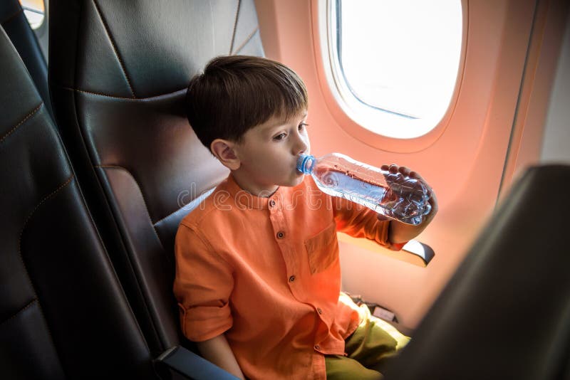 A Passenger Woman on a Airplane Flight Drinking a Bottle of Water Stock  Image - Image of hand, body: 184264045