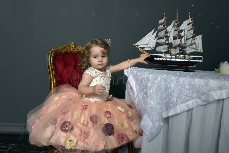 charming little girl in elegant white with a pink dress sitting royalty free stock photography charming little girl in elegant white with a pink dress sitting royalty free stock photography
