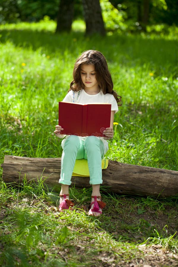 Charming Little Girl in Forest with Book Sitting on Tree Stump Stock ...