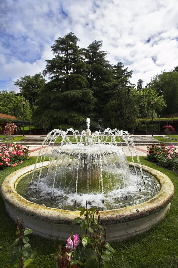 Charming round fountain in a garden of roses