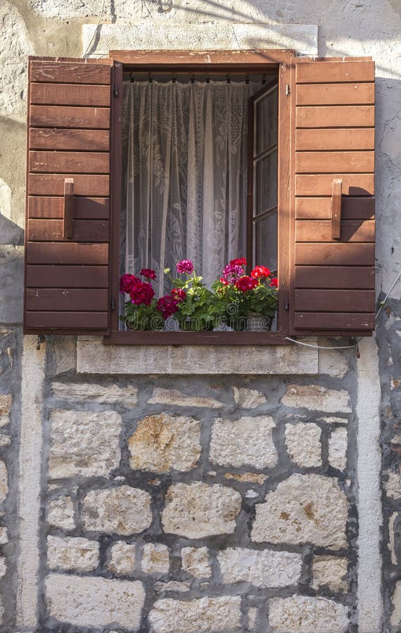 An old building with a charming window with flowers. Bright red flowers wooden window box charming house stock images, royalty-free photos and pictures