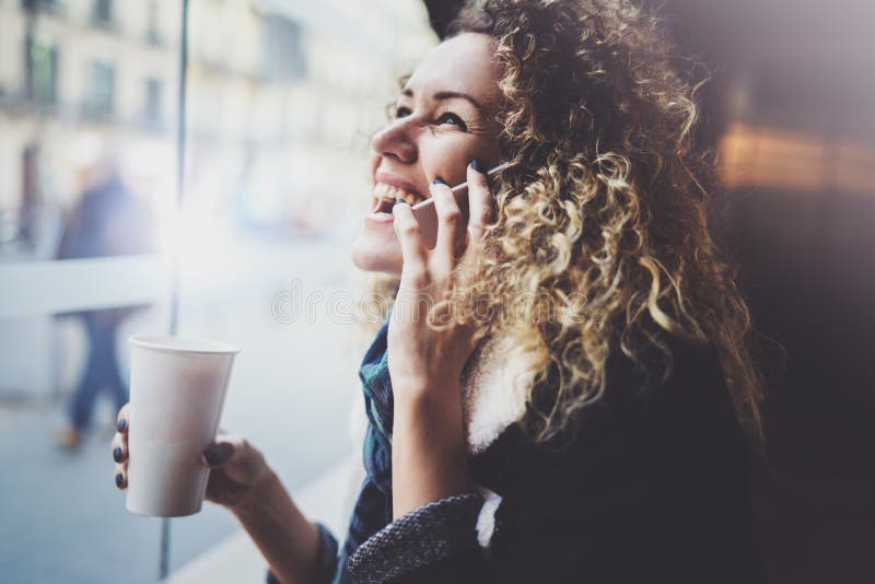 Charming woman with beautiful smile using mobile phone during rest in coffee shop. Blurred background. royalty free stock photography Charming woman with beautiful smile using mobile phone during rest in coffee shop. Blurred background. royalty free stock photography