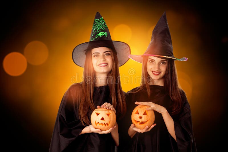 Charming young girls with pumpkins in hands royalty free stock image
