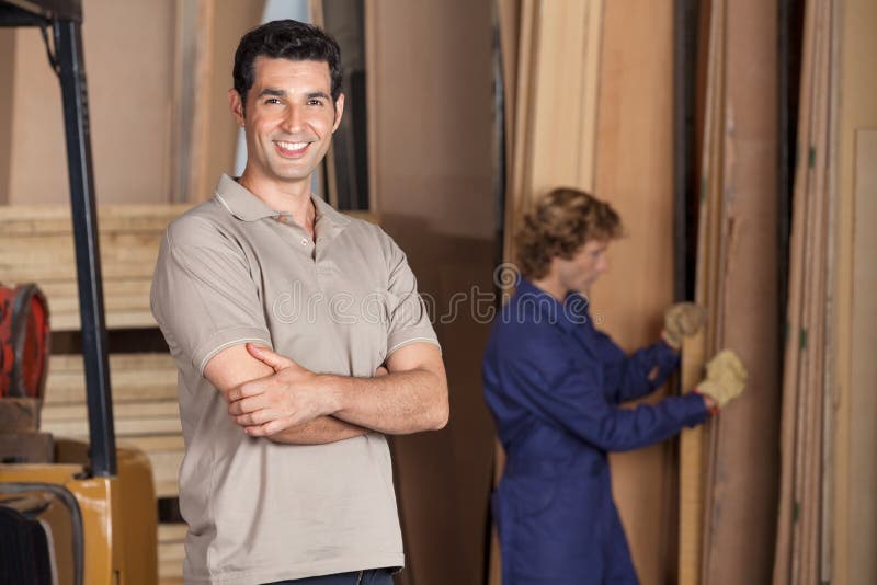 Charpentier sûr With Arms Crossed dans l'atelier image stock Charpentier sûr With Arms Crossed dans l'atelier image stock