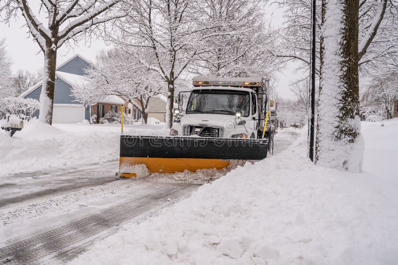 Berks County, Pennsylvania-February 2, 2021: Snowplow clears suburban street after snowstorm. Berks County, Pennsylvania-February 2, 2021: Snowplow clears suburban street after snowstorm.