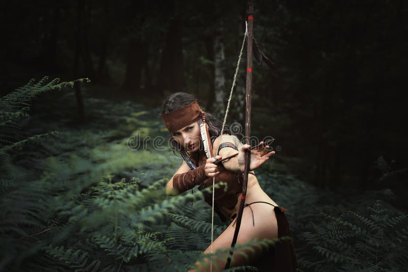 Chasseuse visant avec un arc photo stock