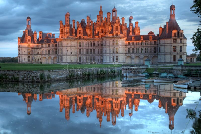 Still sunset over the most famous castle in the world Chateau de Chambord in Loire Valley, France. The castle was completed in 1547 and lies in the middle of a huge hunting ground. Some attribute the design to Leonardo Da Vinci who had some connections with King Francois I and lived in the area at the time of its conception. HDR image. Still sunset over the most famous castle in the world Chateau de Chambord in Loire Valley, France. The castle was completed in 1547 and lies in the middle of a huge hunting ground. Some attribute the design to Leonardo Da Vinci who had some connections with King Francois I and lived in the area at the time of its conception. HDR image.