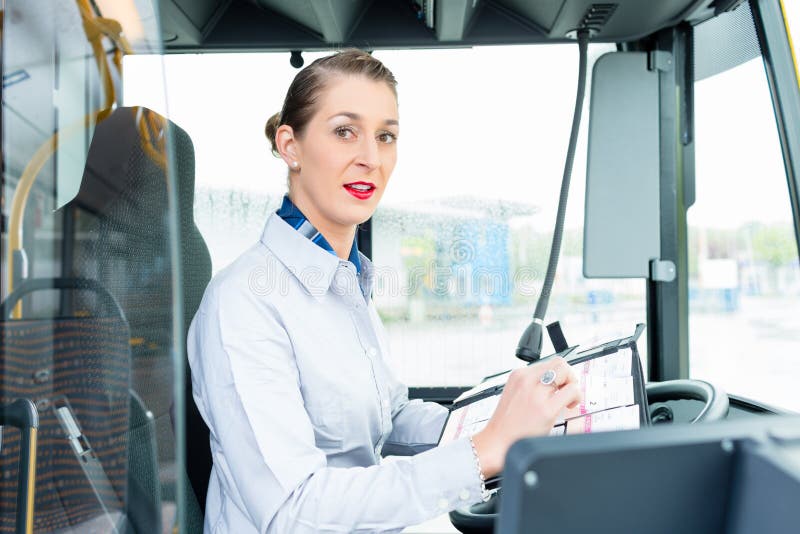 Chauffeur de bus femelle dans le siège de conducteurs photo stock Chauffeur de bus femelle dans le siège de conducteurs photo stock