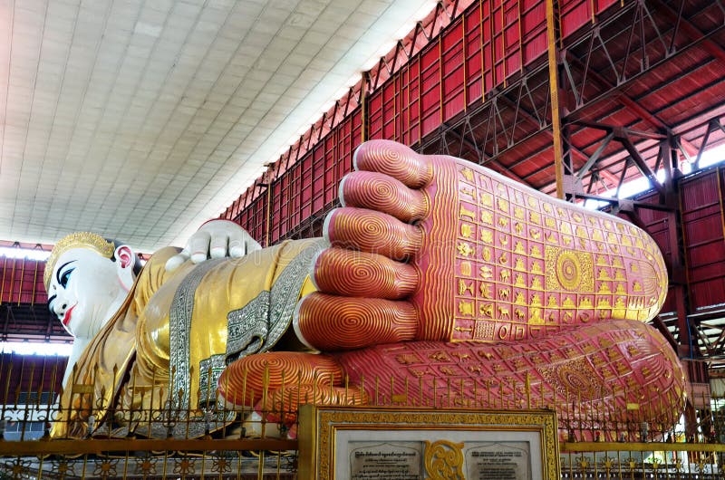 Chauk Htat Gyi Buddha Image The Chauk Htat Gyi Pagoda is famous for its huge image of Reclining Buddha. One of Myanmar’s more revered reclining Buddhas. It is housed in a large metal-roofed shed, only a short distance, located north east of the Shwedagon Pagoda. The image then had a length of 195 feet (59.28m) and a height of 100 feet (30.4m) from the surface of the couch to the halo round the head with the height of the couch itself 5 feet 6 inches above the platform. Extensive reconstruction completed in 1973 extended the length of the image to 216 feet (65.85m) with the height of the couch however, reduced to 4 feet (1.22m). Originally the axis of the head turned towards the west and the visage faced the south, but the reconstructed image has the head aligned towards the east and the visage facing north. Chauk Htat Gyi Buddha Image The Chauk Htat Gyi Pagoda is famous for its huge image of Reclining Buddha. One of Myanmar’s more revered reclining Buddhas. It is housed in a large metal-roofed shed, only a short distance, located north east of the Shwedagon Pagoda. The image then had a length of 195 feet (59.28m) and a height of 100 feet (30.4m) from the surface of the couch to the halo round the head with the height of the couch itself 5 feet 6 inches above the platform. Extensive reconstruction completed in 1973 extended the length of the image to 216 feet (65.85m) with the height of the couch however, reduced to 4 feet (1.22m). Originally the axis of the head turned towards the west and the visage faced the south, but the reconstructed image has the head aligned towards the east and the visage facing north.