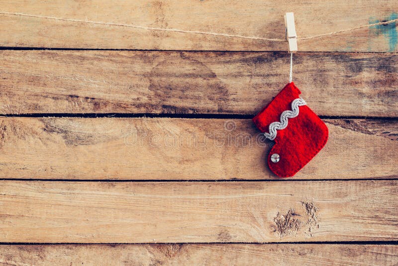 Chaussette rouge pour des cadeaux de Santa accrochant au-dessus du fond en bois rustique images stock Chaussette rouge pour des cadeaux de Santa accrochant au-dessus du fond en bois rustique images stock