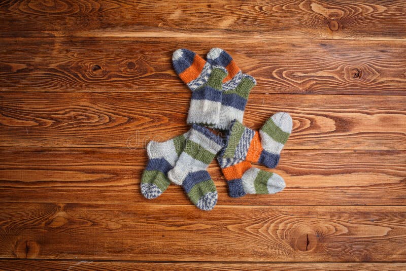Chaussettes tricotées multicolores rayées de bébé sur un fond en bois photos stock Chaussettes tricotées multicolores rayées de bébé sur un fond en bois photos stock