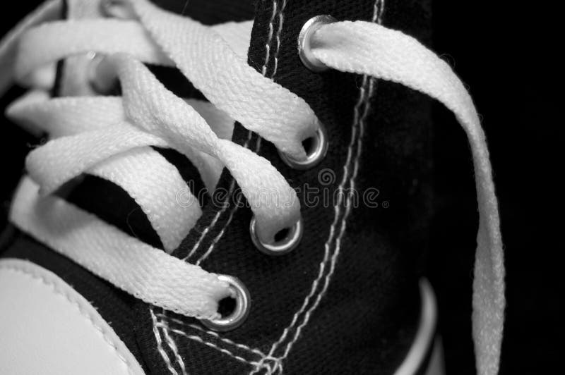 Chaussure noire avec des lacets blancs photo stock