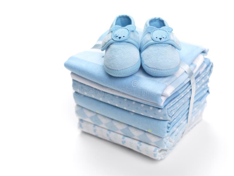 Cute blue baby boy shoes on a pile of swaddling blankets isolated on white background. Cute blue baby boy shoes on a pile of swaddling blankets isolated on white background