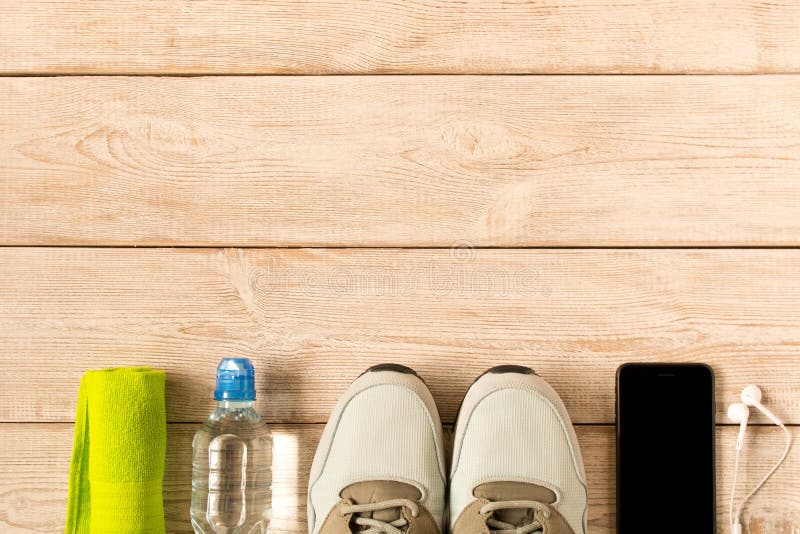 Chaussures de course et accessoires gris de forme physique sur le fond en bois L'espace vide des textes photographie stock Chaussures de course et accessoires gris de forme physique sur le fond en bois L'espace vide des textes photographie stock
