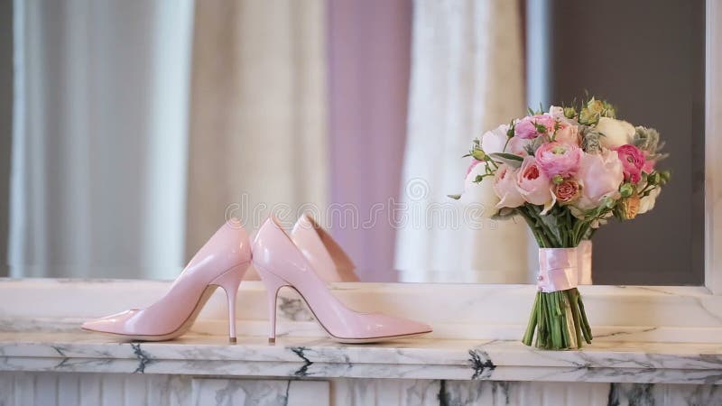 Chaussures du ` s de femme et bouquet nuptiale