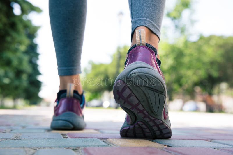 Chaussures sur les pieds femelles fonctionnant sur la route images libres de droits Chaussures sur les pieds femelles fonctionnant sur la route images libres de droits