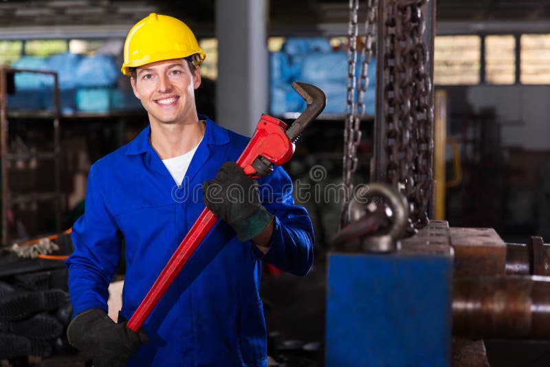Happy factory worker with monkey wrench in workshop. Happy factory worker with monkey wrench in workshop