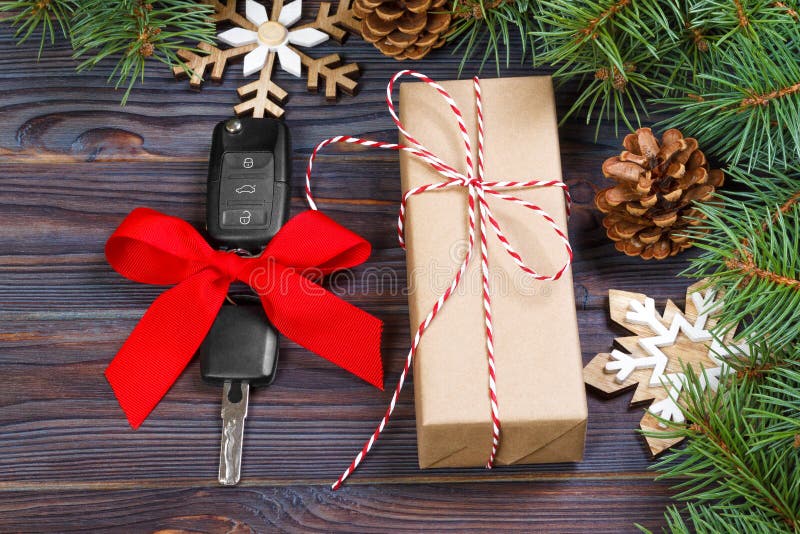 Chave do carro com curva colorida com a decoração da caixa de presente e do Natal no fundo de madeira imagens de stock royalty free Chave do carro com curva colorida com a decoração da caixa de presente e do Natal no fundo de madeira imagens de stock royalty free