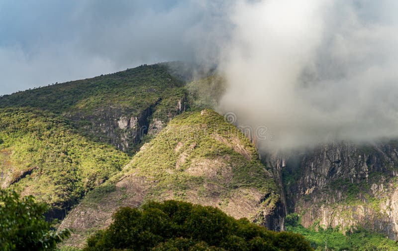 Chaîne de montagnes majestueuse recouverte de brume et de forêt dense. Une vue imprenable sur une montagne rocheuse avec des chutes verticales profondes, entourée d'une forêt luxuriante et entourée de brume matinale. le terrain accidenté et les sommets imposants en font une aventure pour les âmes les plus courageuses.