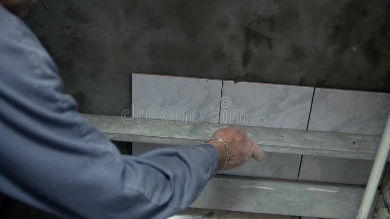 Checking the straightness of tiles stock video