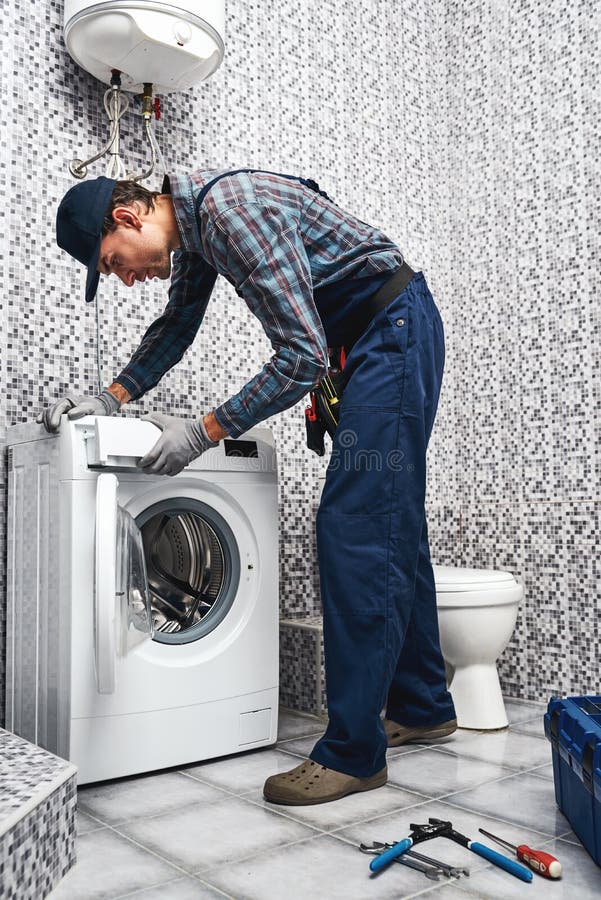 Washing Mashine is Leaked. Working Man Plumber Repairs a Washing