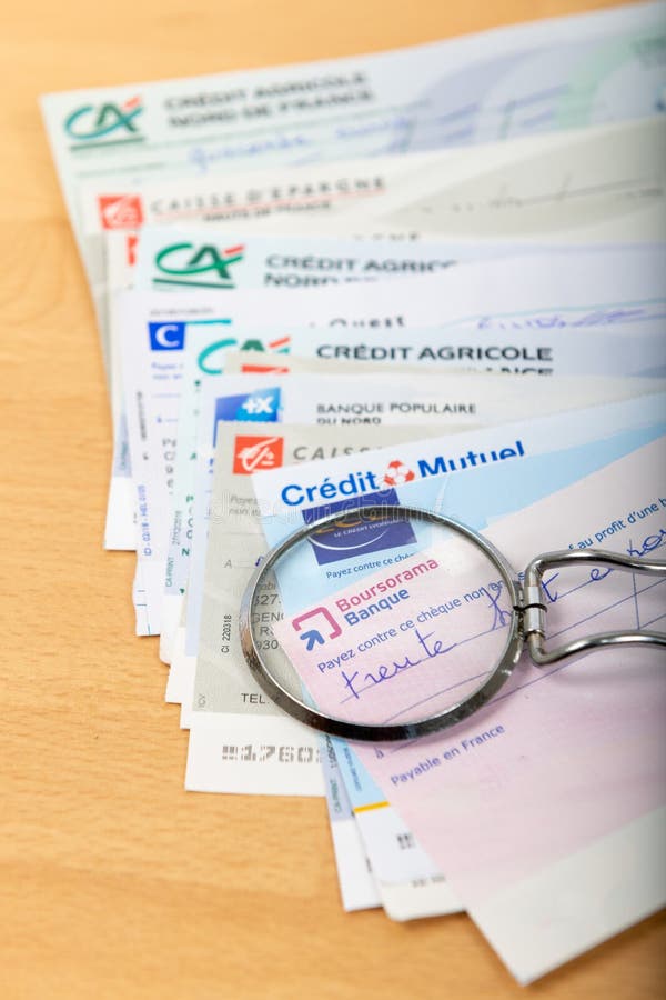 Checks Of Different French Banks Set On A Wooden Desk Editorial
