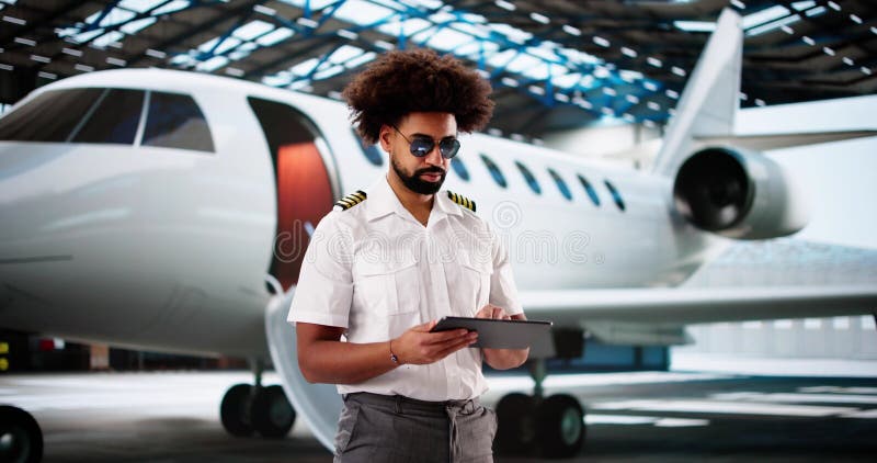 Cheerful African-American pilot using tablet stock images