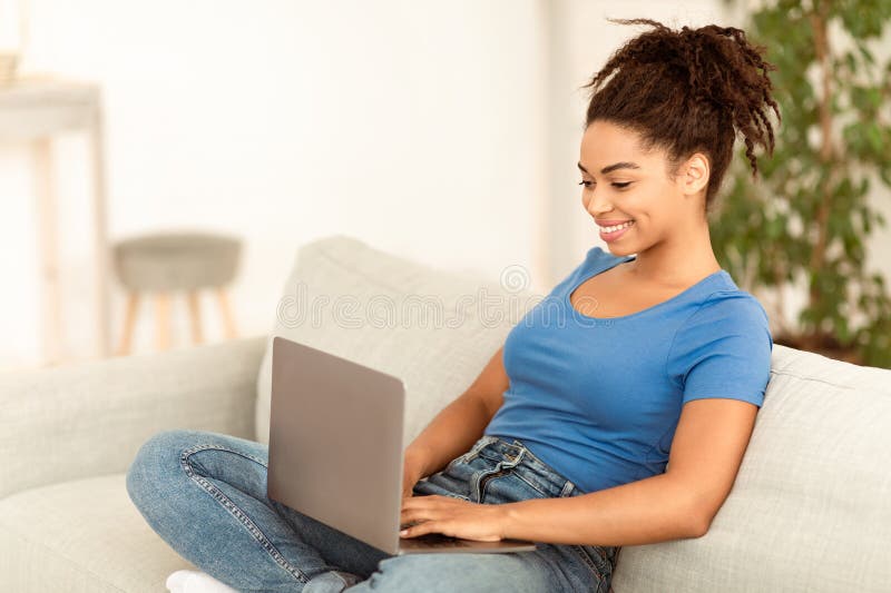 Cheerful African Freelancer Girl Använder bärbar dator som arbetar hemma arkivbilder